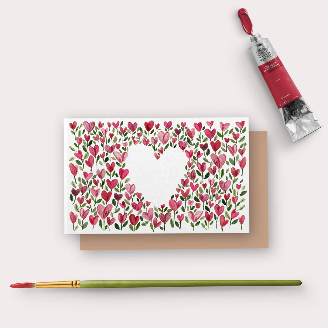 a card with a heart on it next to a paintbrush