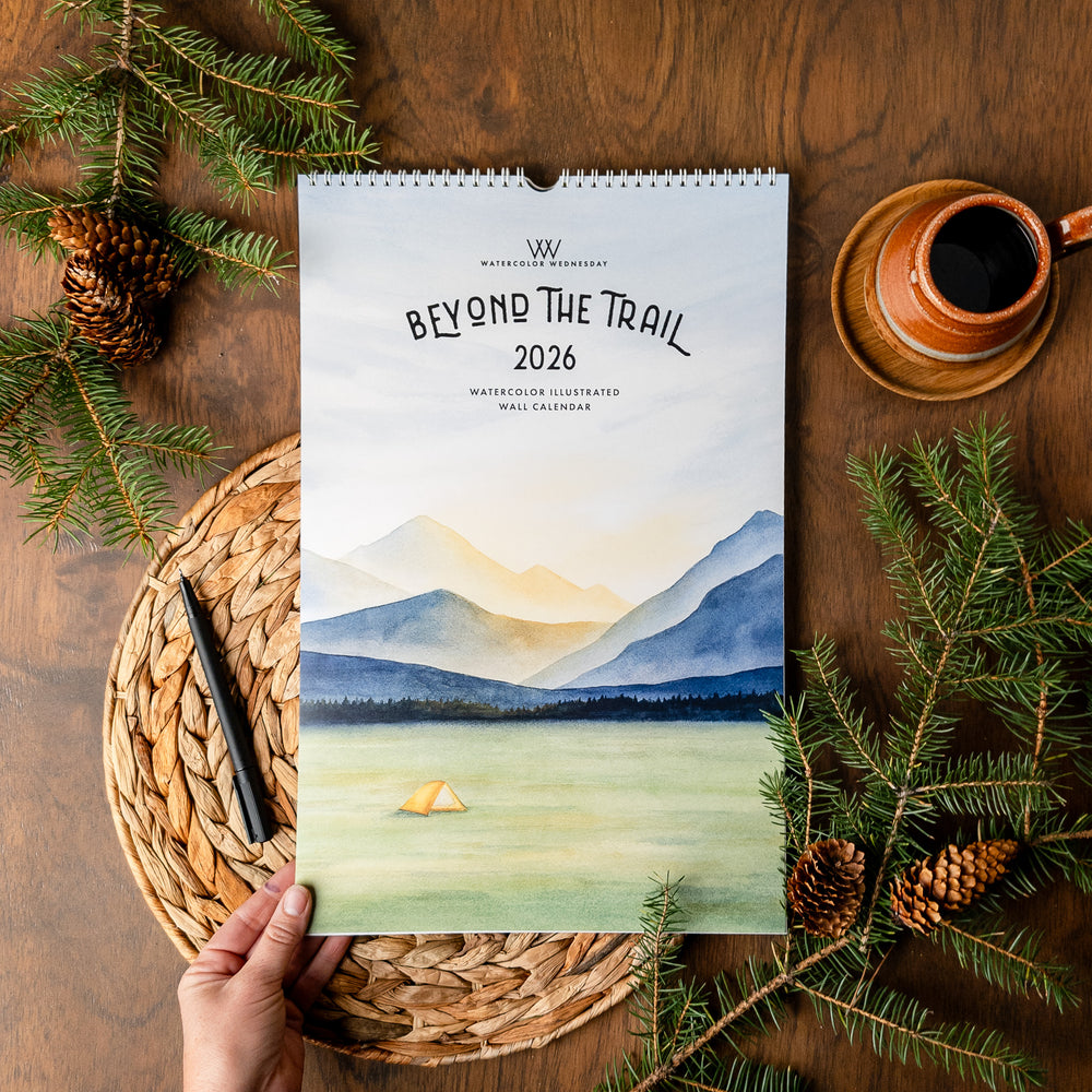 2026 Beyond the Trail Calendar flatlay with hand holding
