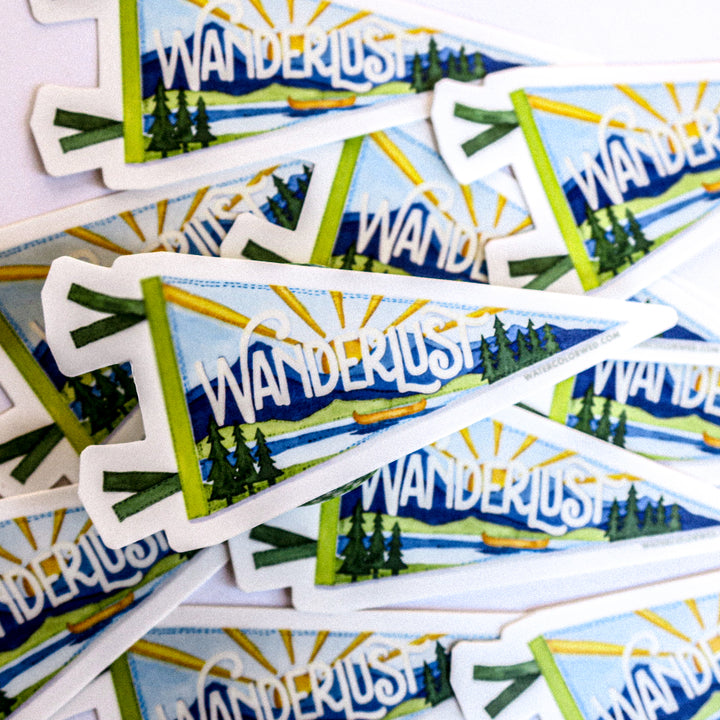 a bunch of stickers that are on a table they all say wanderlust and have an outdoor scene