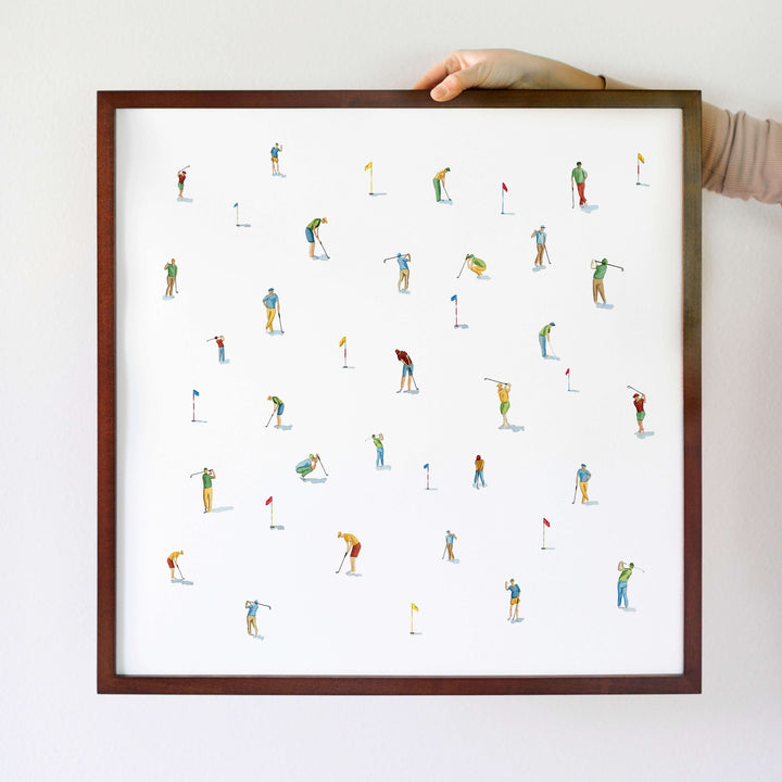 a person holding a framed picture of a group of skiers