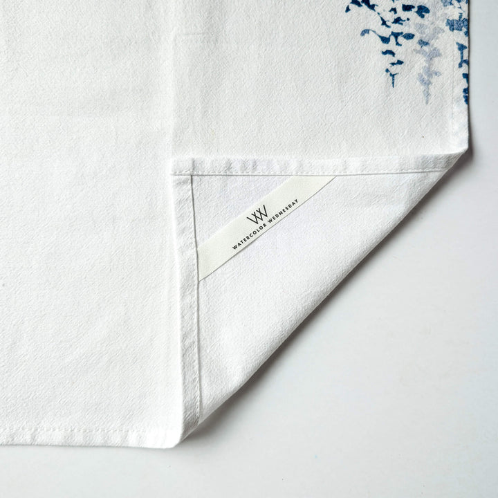 a close up of a white towel with blue flowers on it