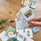 a person holding a bunch of cards on top of a wooden floor