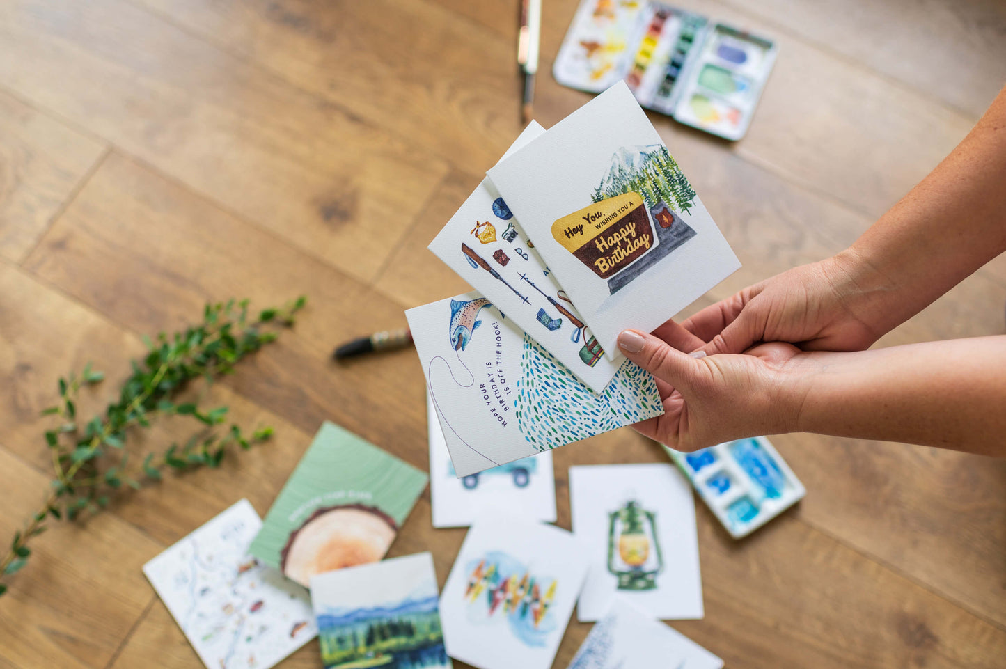 a person holding a bunch of cards on top of a wooden floor