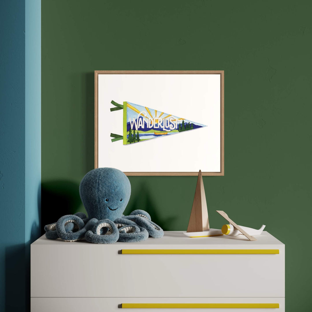 an octopus is sitting on a dresser next to a picture of an adventure pennant