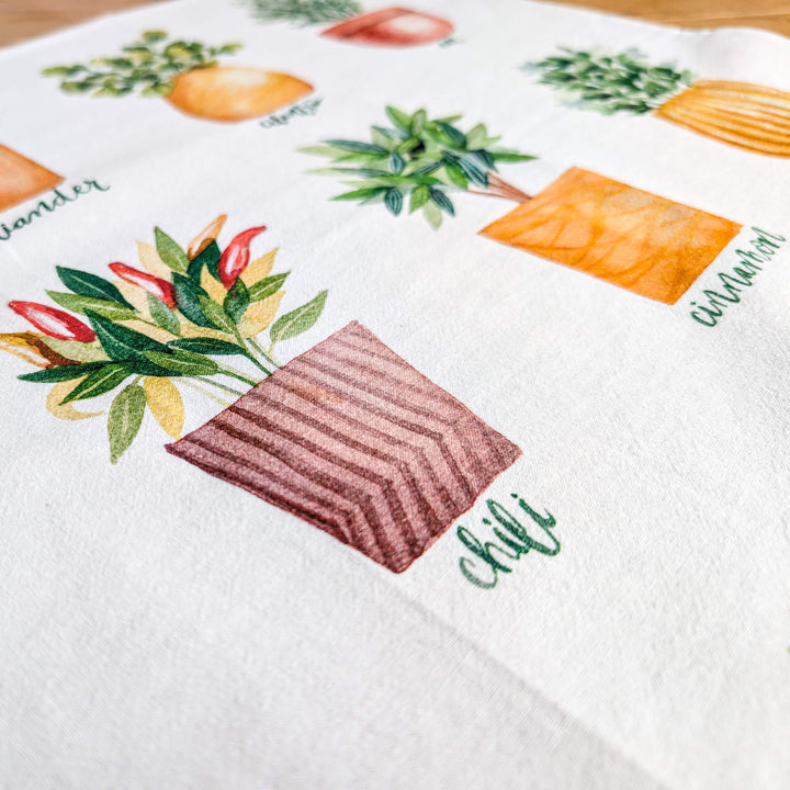 a close up of a table cloth with a potted plant on it