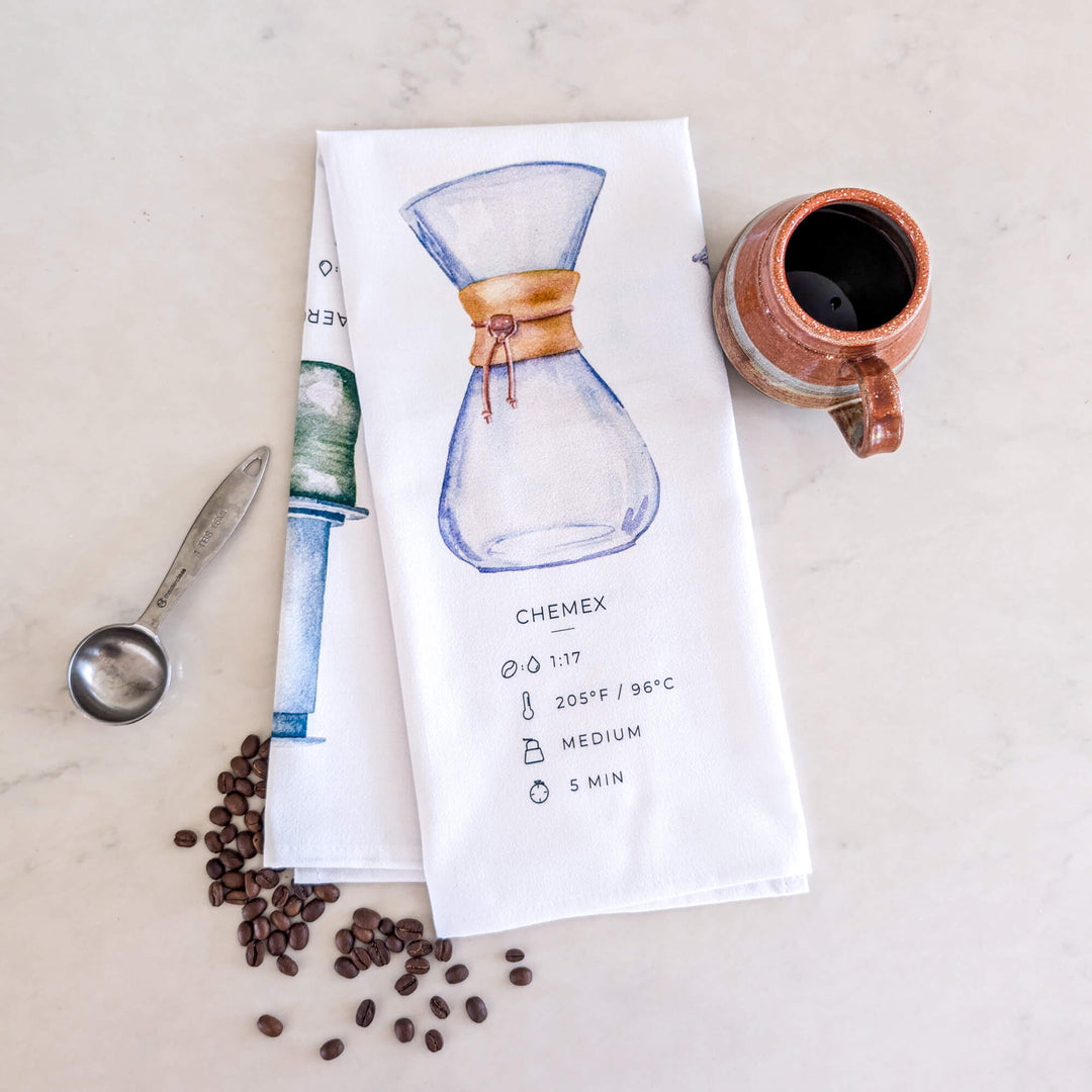 a tea towel with a picture of a coffee pot and a measuring spoon