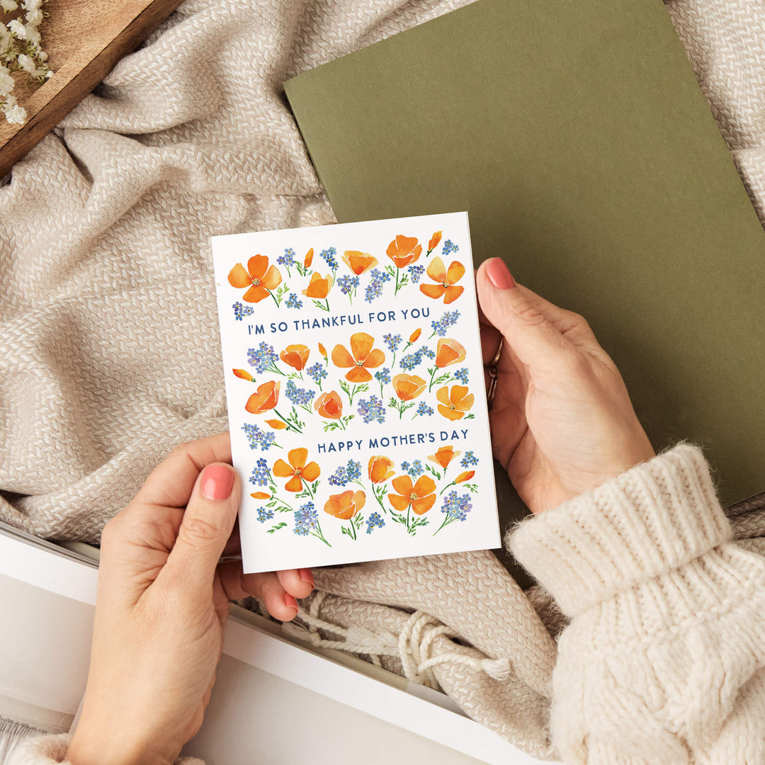 a person holding a card with flowers on it