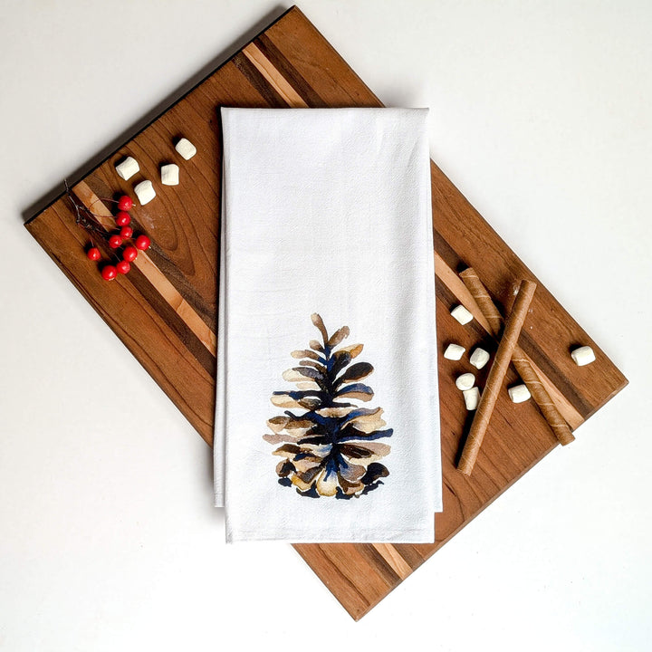 a pine cone on a white towel on a cutting board