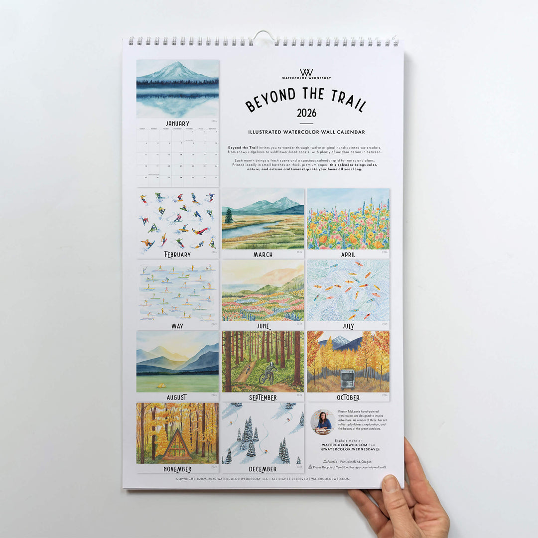 Calendar titled 'Beyond the Trail' held by a hand on a white background