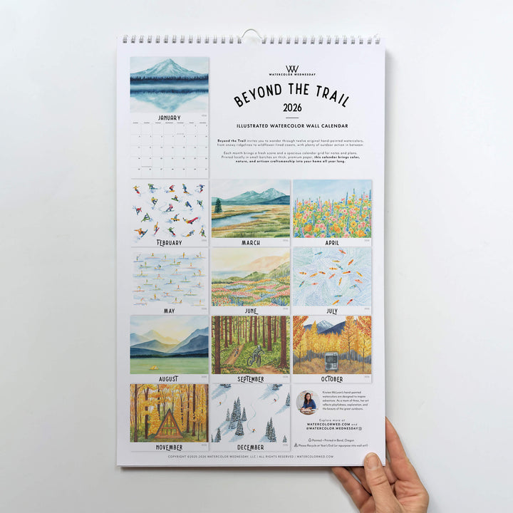 Calendar titled 'Beyond the Trail' held by a hand on a white background