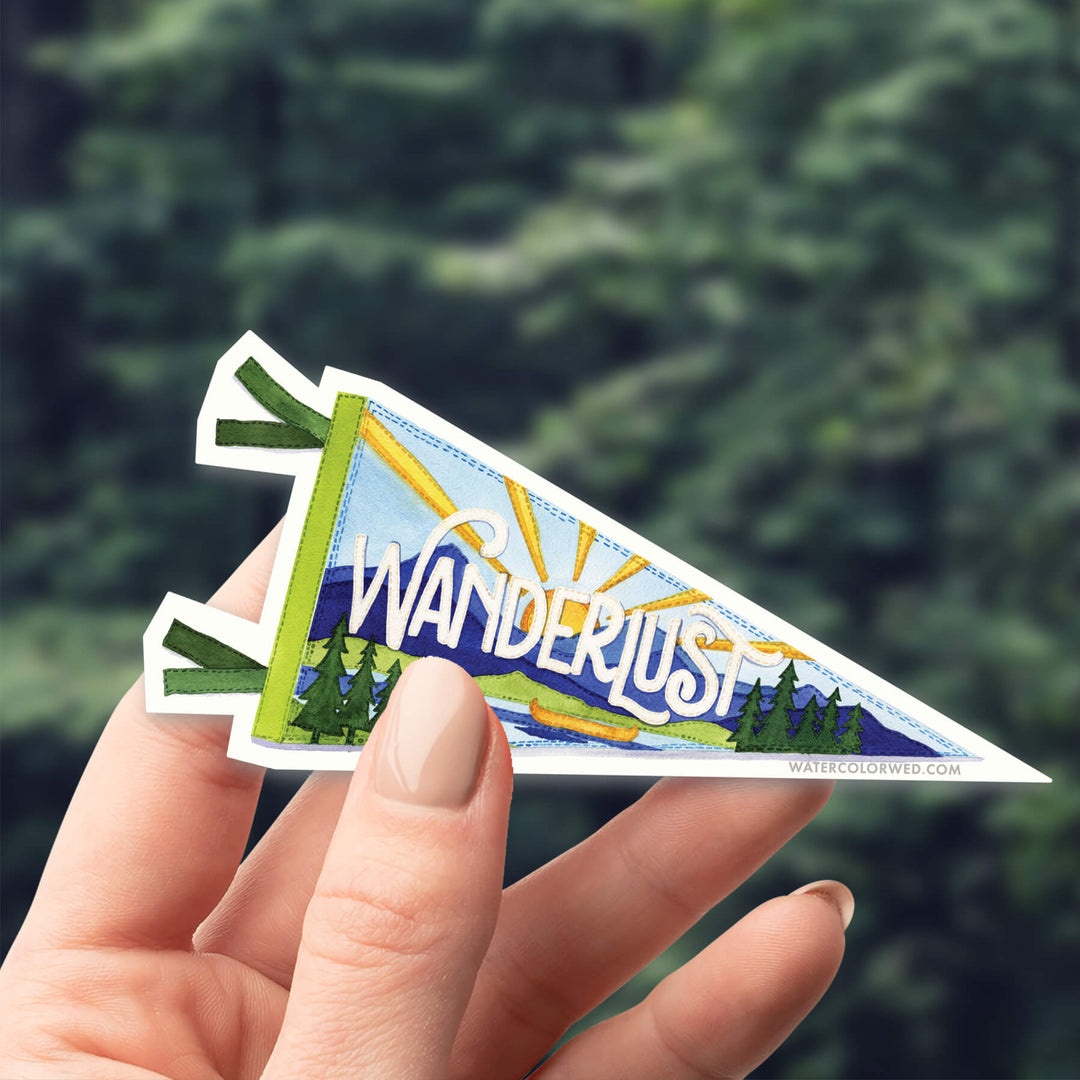 a person holding a sticker that says wanderlust