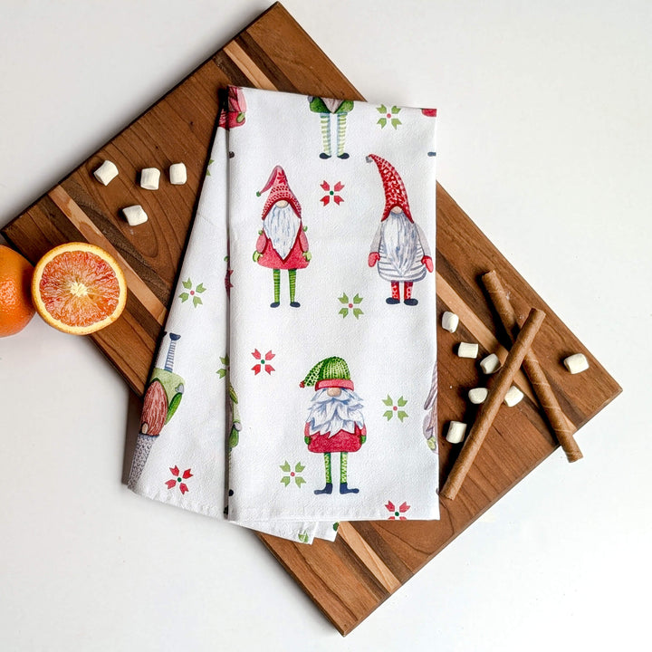 two napkins with gnomes on them next to an orange