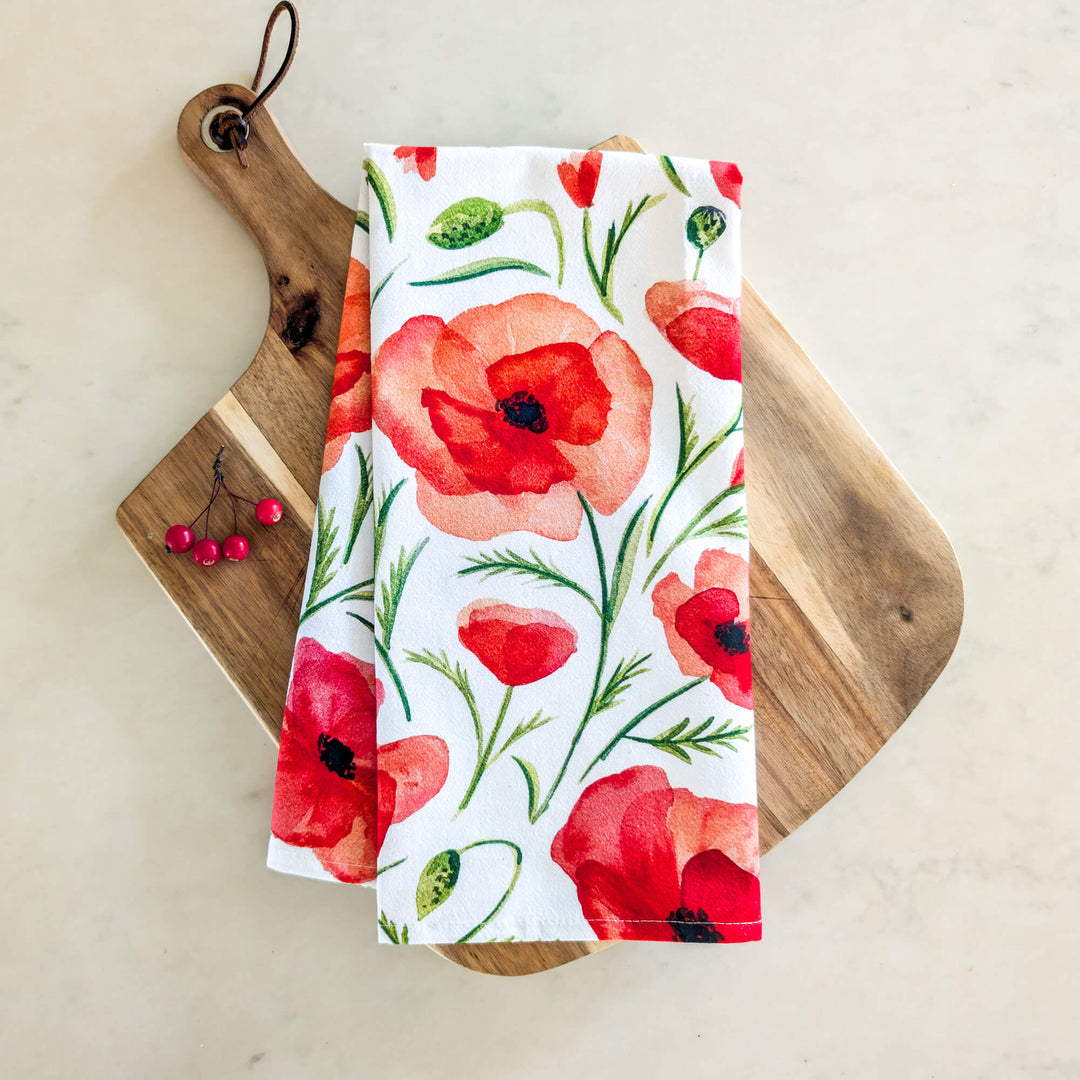 a wooden cutting board topped with a white and red napkin