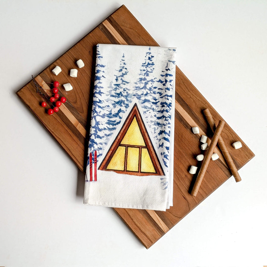 a tea towel with a picture of a cabin on it