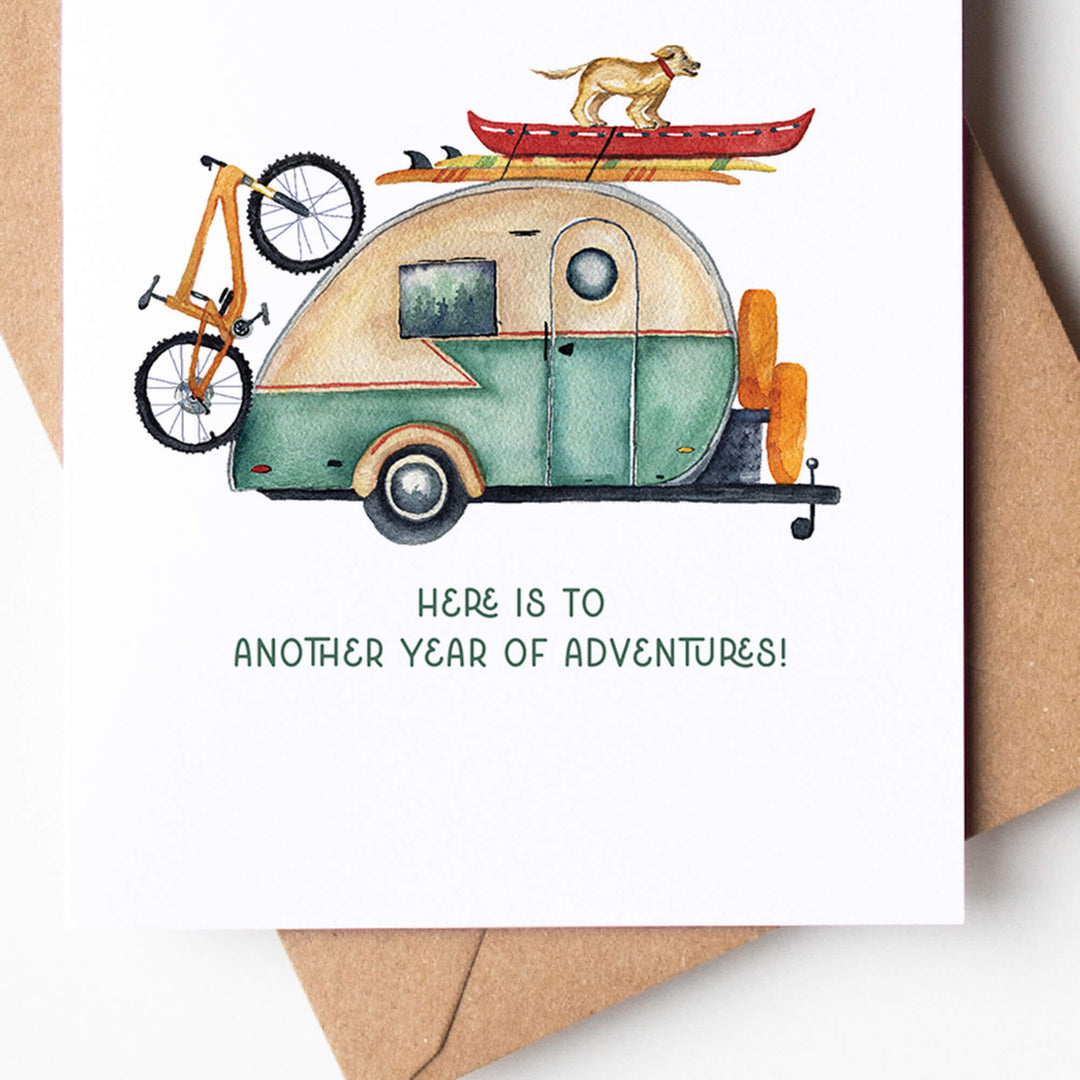 a outdoorsy themed birthday card with an image of a camper with a dog on top of it