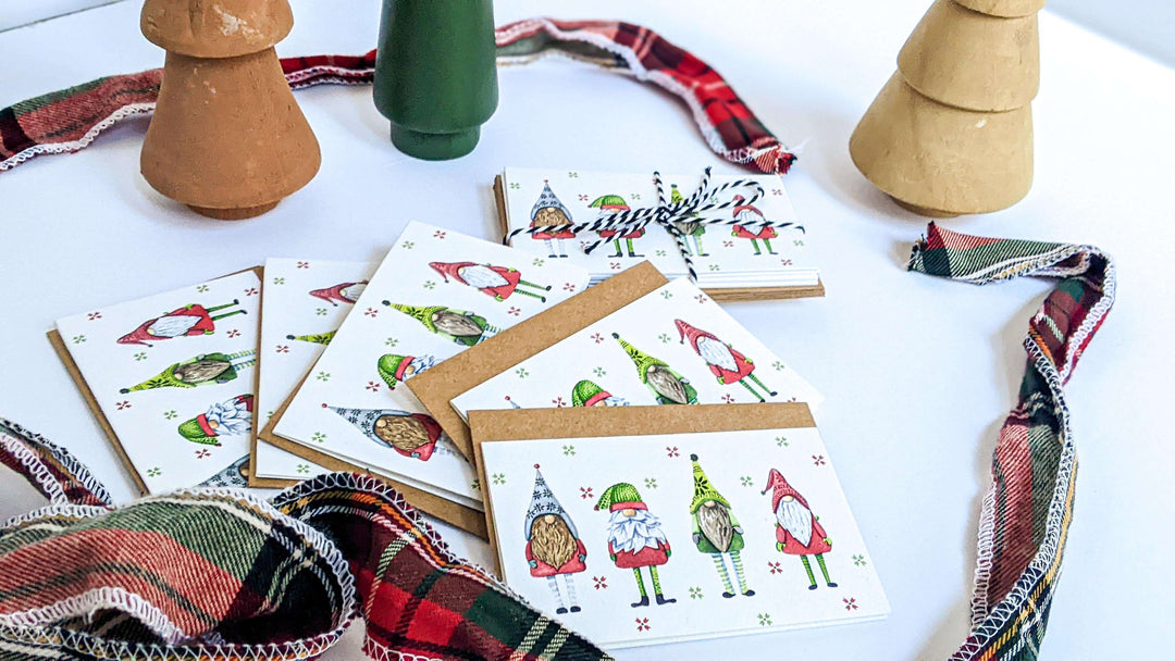 a table topped with lots of festive holiday cards next to a vase