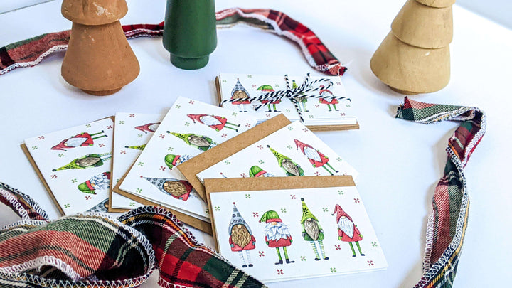 a table topped with lots of festive holiday cards next to a vase