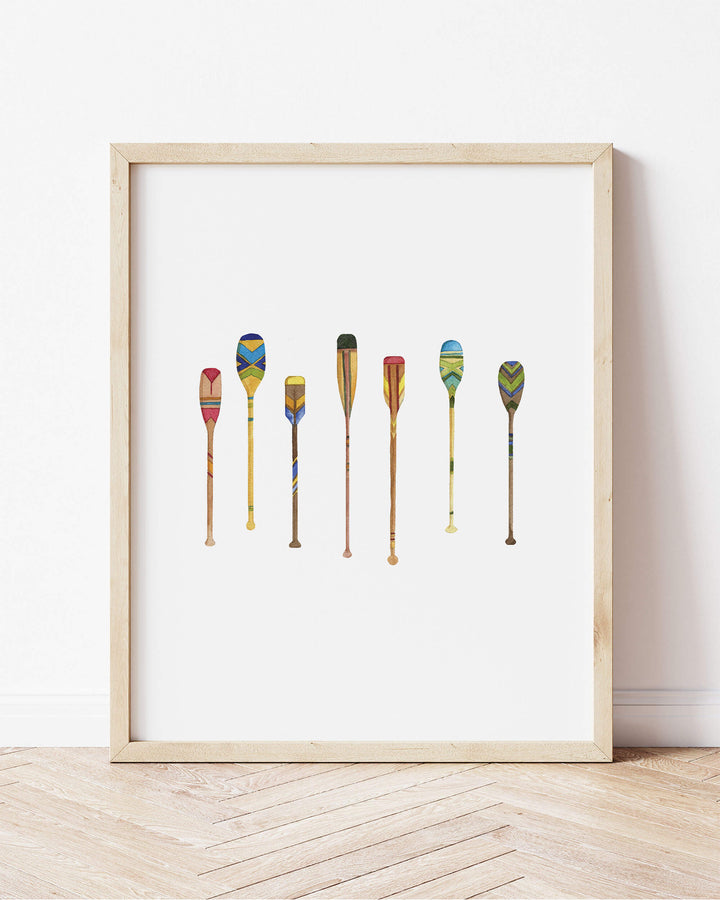 a framed picture of a row of colorful paddles on a white background