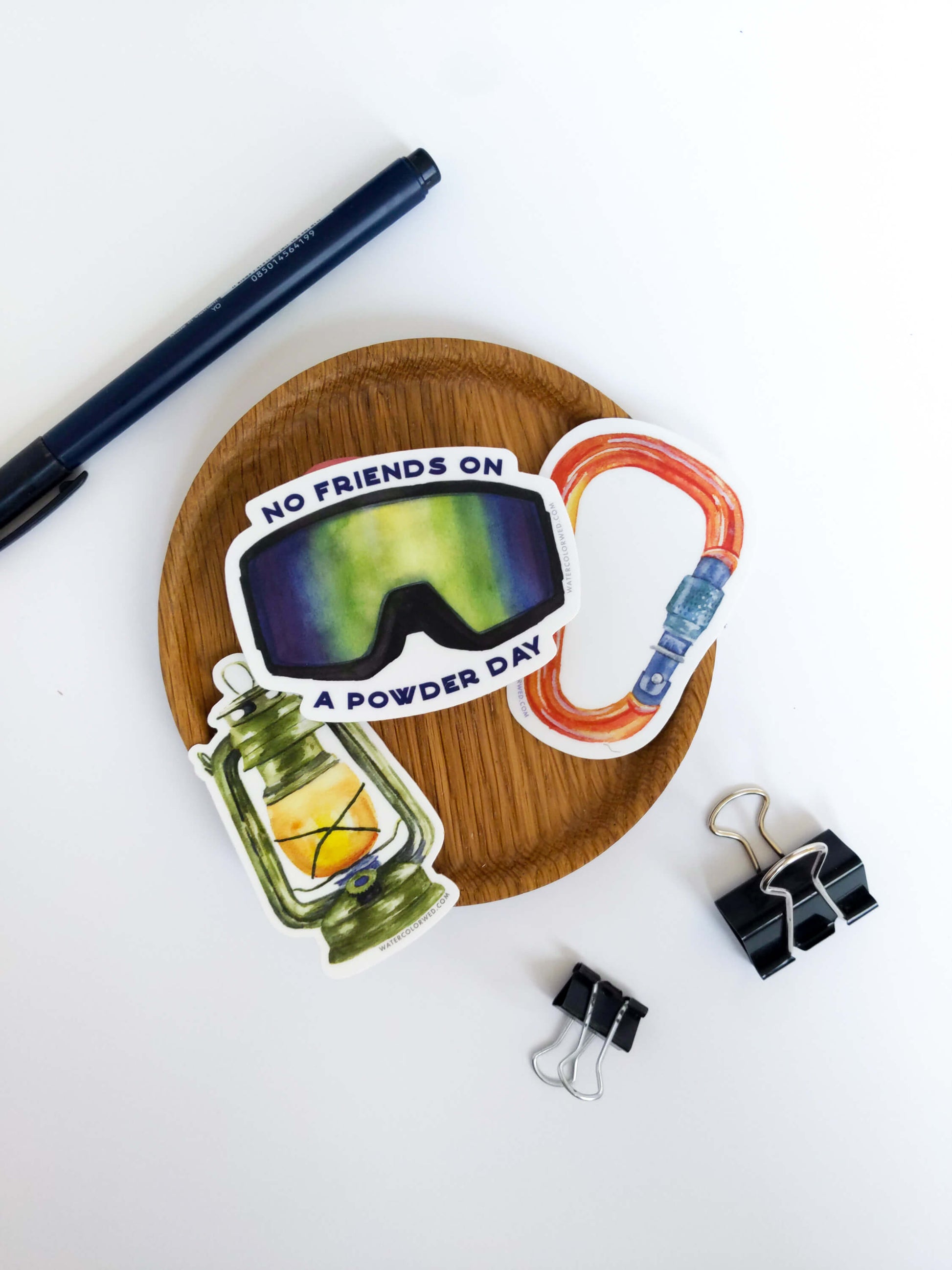 a wooden plate with a stack of ski goggle stickers on it