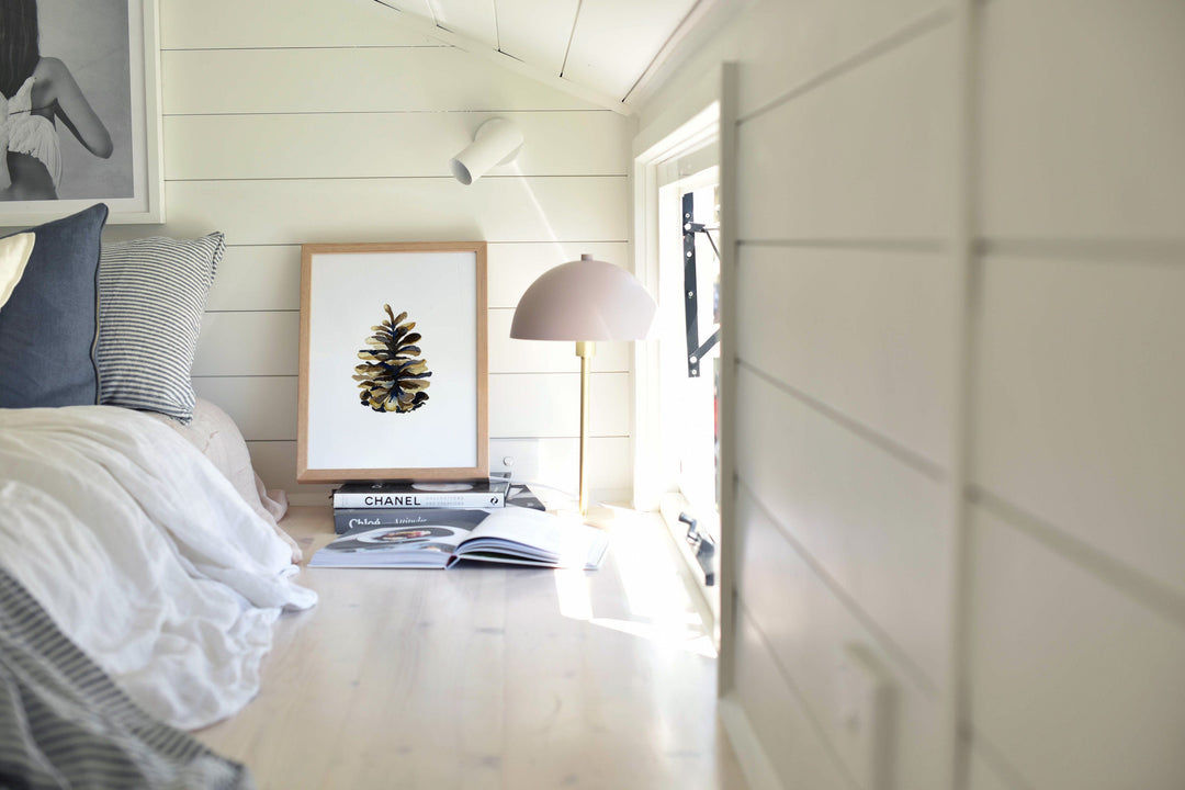 a picture of a pine cone on a wall above a bed