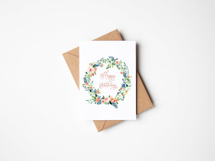 a minimalist birthday card with a wreath of flowers on it